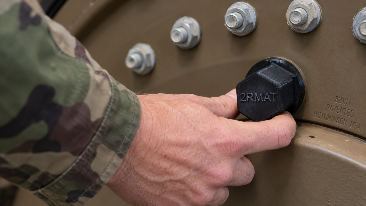 Fitting a black 3D-printed protective cap onto equipment